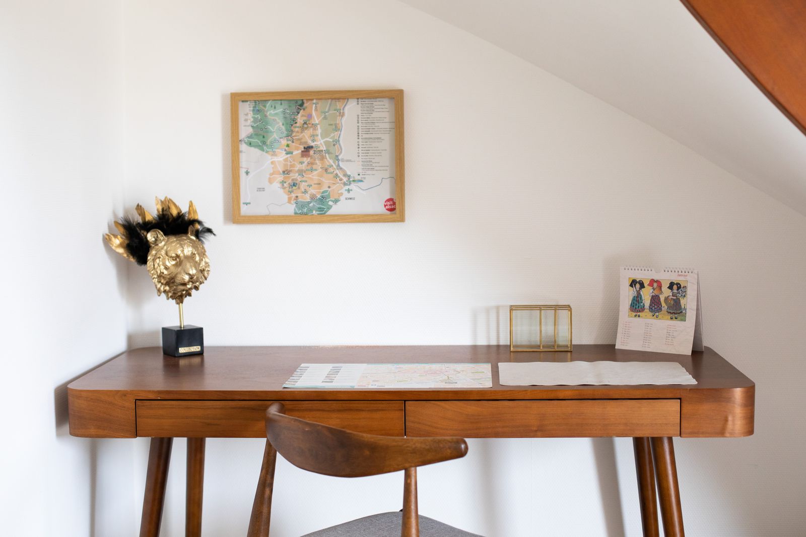 Bureau en bois et chaise, carte ancienne au mur